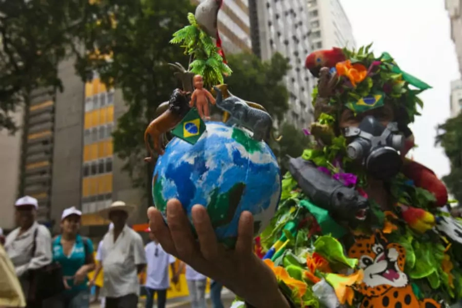 A demonstrator wears a costume that represents the Amazon rainforest during a march at the Rio+20 Conference in Brazil (Courtesy Reuters).