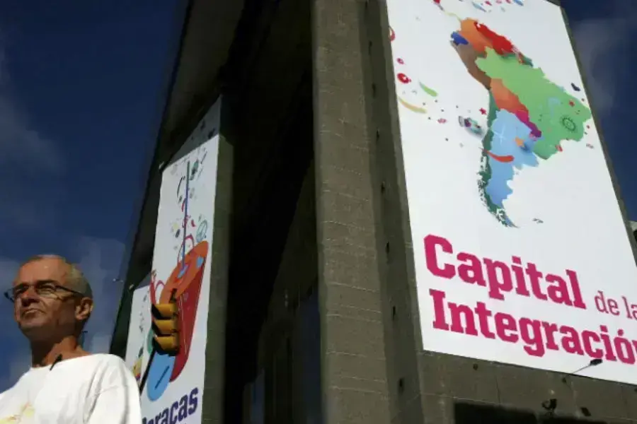 A man walks past a banner reading 'Capital of integration' in Caracas