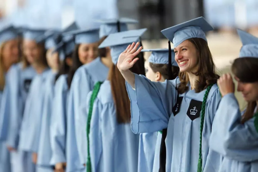 A graduating senior waves as she arrives at the 2009 Barnard College commencement (Chip East/Courtesy Reuters).