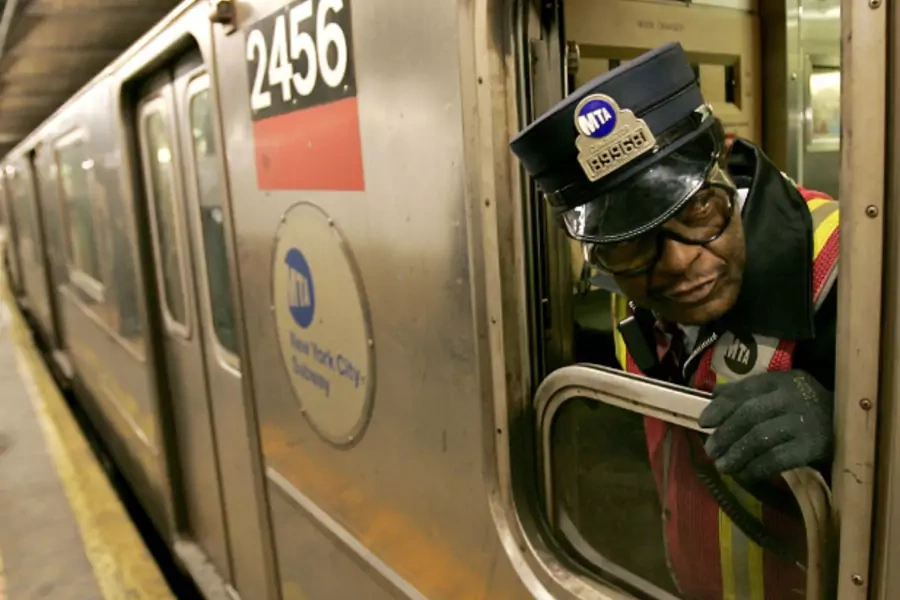 A New York subway conductor checks the train doors before departing Columbus Circle station in December 2005 (Courtesy Reuters).