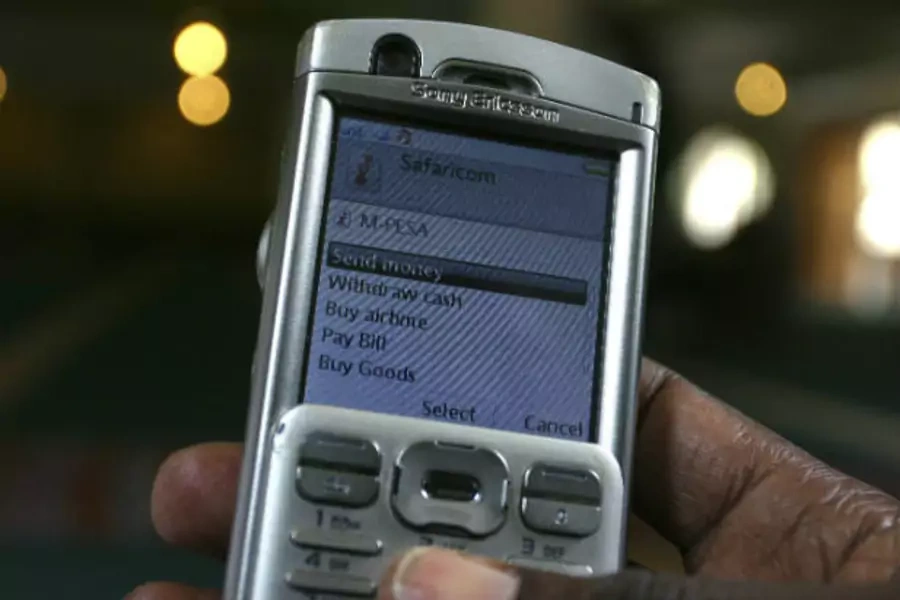 A man scrolls through his mobile phone to carry out a transaction via M-Pesa in Nairobi, Kenya on May 12, 2009 (Noor Khamis/Courtesy Reuters).