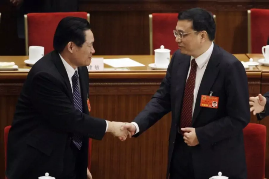 Li Keqiang, right, shakes hands with China's Politburo Standing Committee Member Zhou Yongkang after Li was elected Vice Premier in Beijing on March 17, 2008.