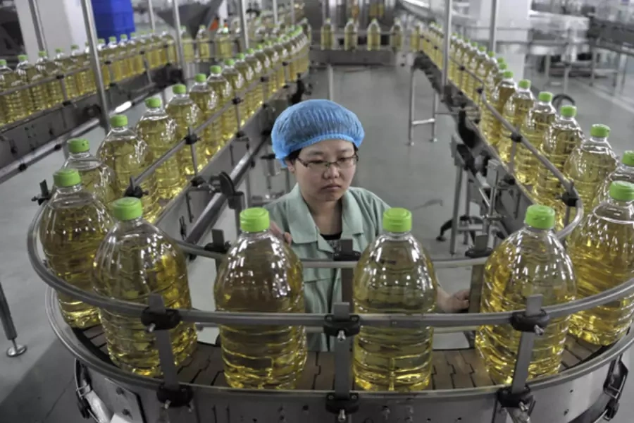 An employee works at the production line of an edible oil company in Sanhe, Hebei April 12, 2011.