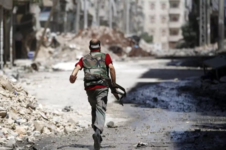 A Free Syrian Army fighter runs during clashes with Syrian army in Aleppo (Goran Tomasevic/Courtesy Reuters).