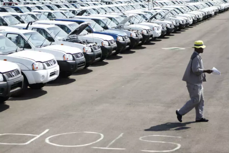 A worker walks near a row of cars at Nissan's manufacturing plant in Rosslyn, outside Pretoria, South Africa on September 11, 2009 (Siphiwe Sibeko/Courtesy Reuters).