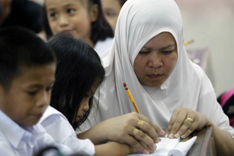 A mother assists her daughter on her first day of school in Manila, Philippines on June 15, 2010 (Romeo Ranoco/Courtesy Reuters).