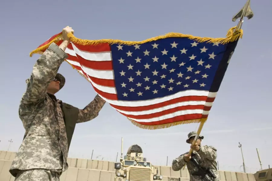 U.S. Army soldiers roll up a national flag after their headquarters' change of command ceremony in Afghanistan in 2010. (Shamil Zhumatov/ courtesy Reuters)