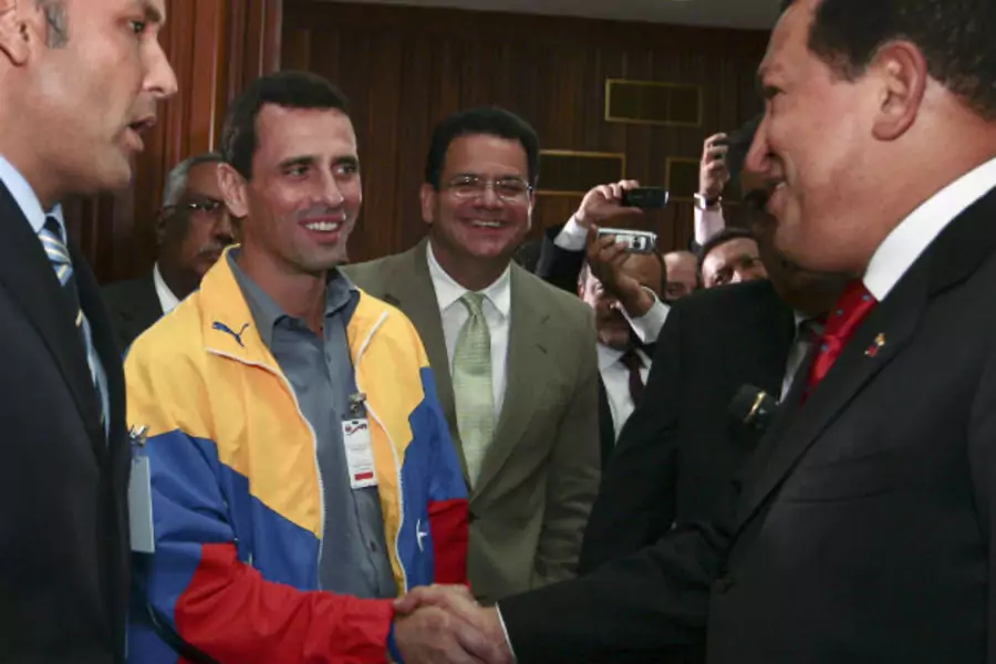 Venezuela's President Hugo Chavez shakes hands with opposition governor from the state of Miranda, Henrique Capriles, during a ceremony at Miraflores Palace in Caracas