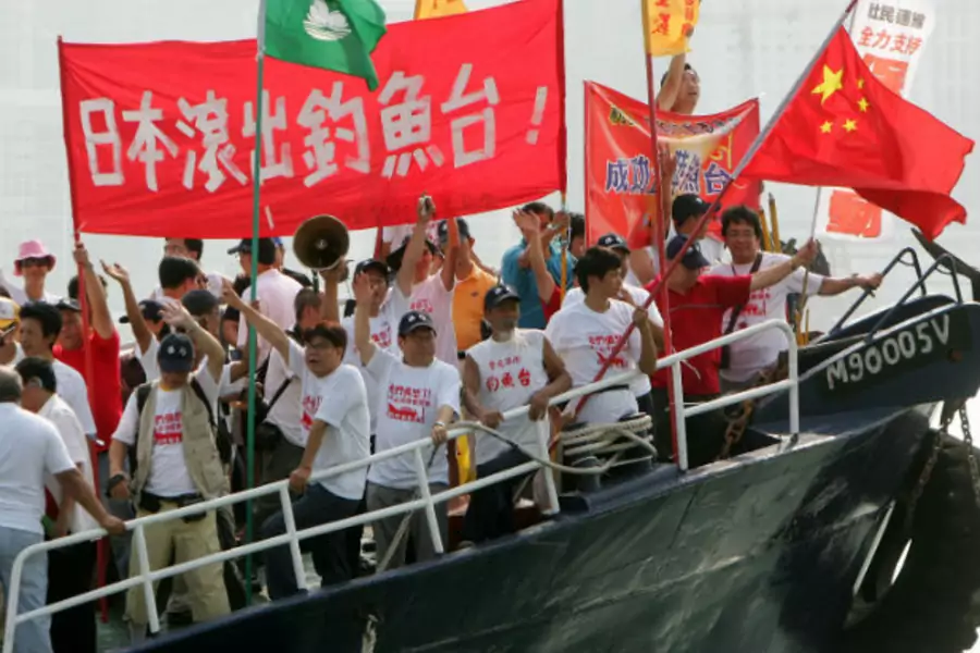 Activists from the Hong Kong-based Action Committee for Defending the Diaoyu Islands shout slogans and wave the Chinese flag o...g October 22, 2006. The banner written in Chinese reads "Japan get out of the Diaoyu Islands". (Paul Yeung / Courtesy Reuters)