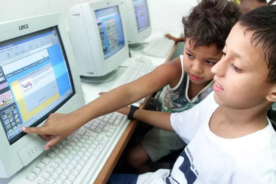 Brazilian children Alexandre da Costa (L) and Augusto Ribeiro use a computer at Mare slum in Rio de Janeiro (Sergio Moraes/Courtesy Reuters).