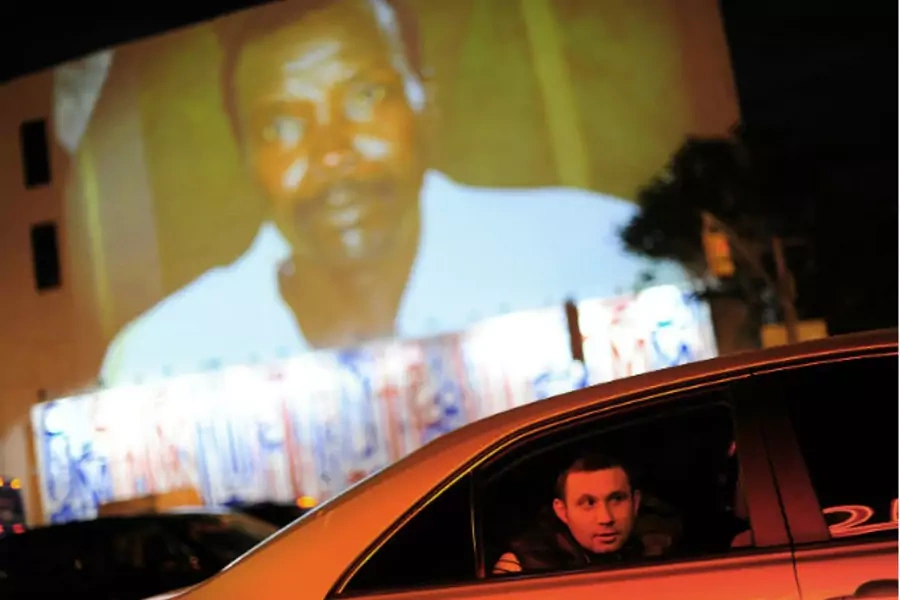 A man looks out of the window of a car which drives under a projection that is part of the non-profit organization Invisible Children's "Kony 2012" viral video campaign, in New York on April 20, 2012 (Keith Bedford/Courtesy Reuters).