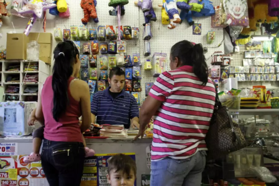 Oswaldo Alvarado helps customers at Importaciones Valentinas grocery and pinata store in Phoenix