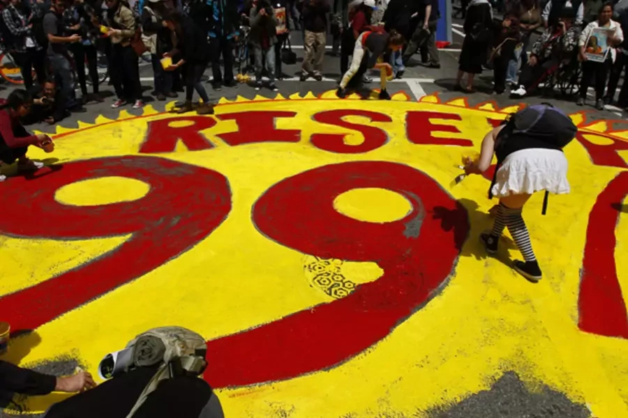 Protestors paint a 99% slogan on the street during May Day demonstrations in San Francisco on May 1, 2012 (Robert Galbraith/Courtesy Reuters).