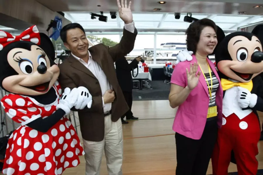 Chinese tourists pose for a picture with Mickey and Minnie Mouse (Jason Reed/Courtesy Reuters).