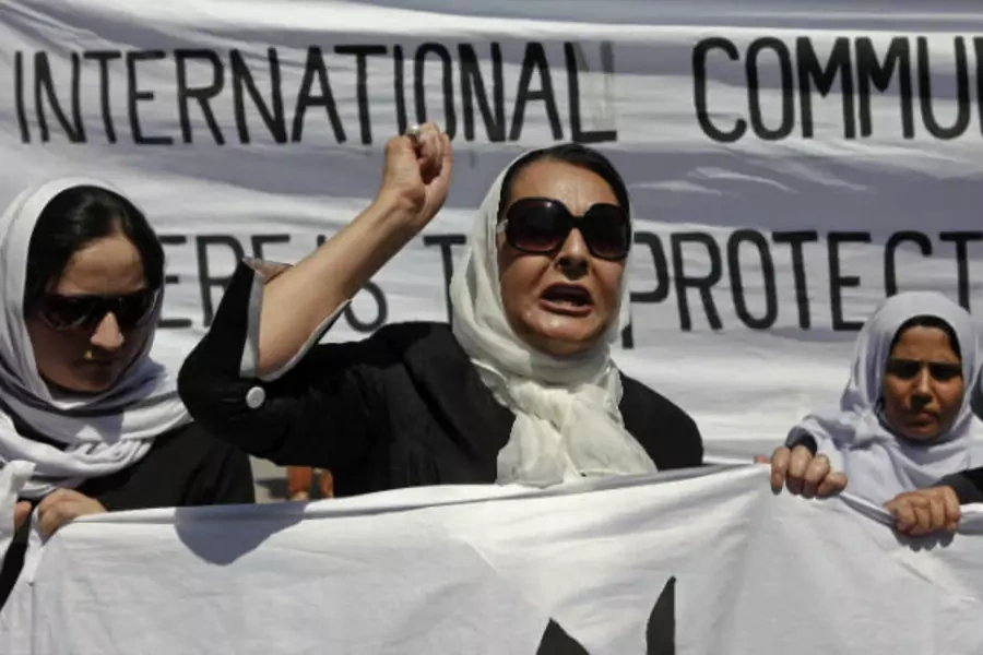 Women march with banners to protest the recent public execution of a young woman, in Kabul July 11, 2012 (Omar Sobhani/Courtesy Reuters).