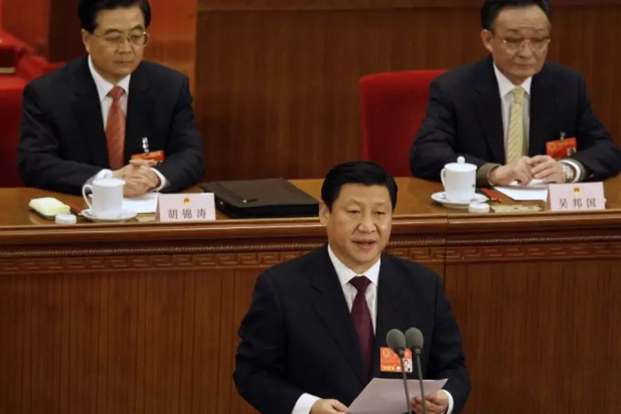 Current Vice President Xi Jinping reads a statement as President Hu Jintao (L) and parliament chief Wu Bangguo listen during the 11th National People's Congress in Beijing on March 11, 2008.