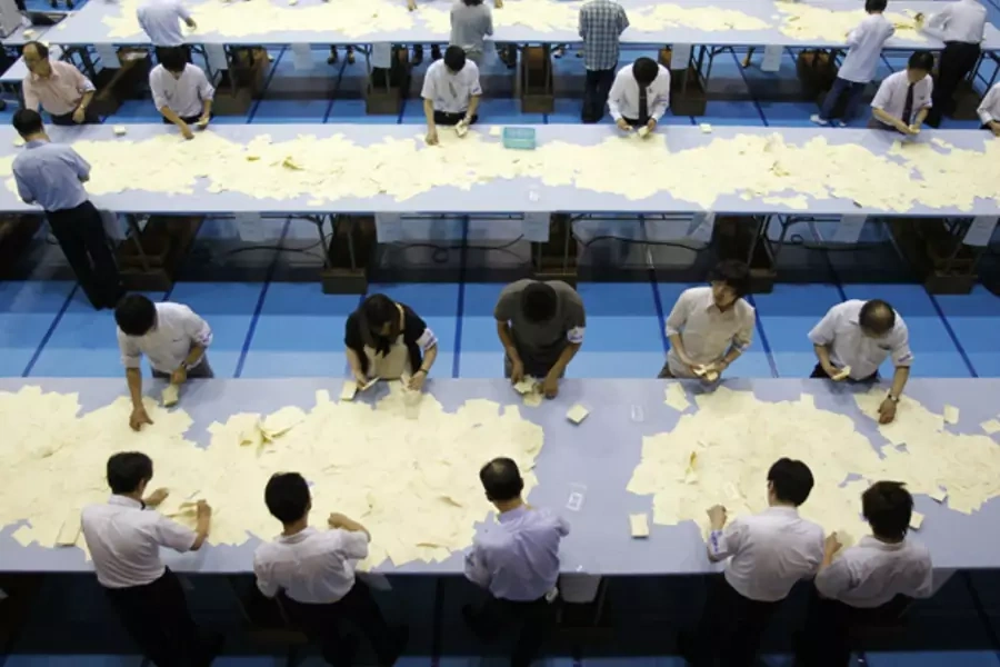 Election officers count votes at a ballot counting center for the upper house election in Tokyo July 11, 2010.