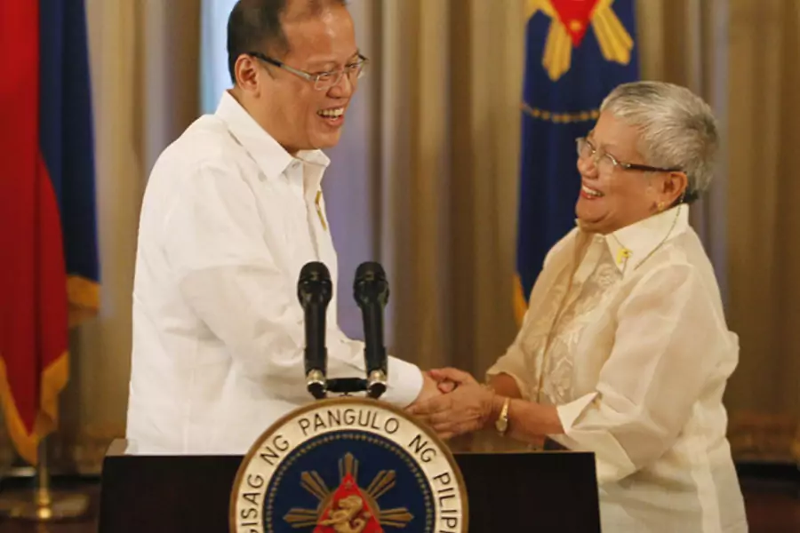 Philippine president Benigno Aquino shakes hands with presidential adviser on the peace process, Secretary Teresita Quintos-Deles, after his speech on national television at the Malacanang palace in Manila October 7, 2012.