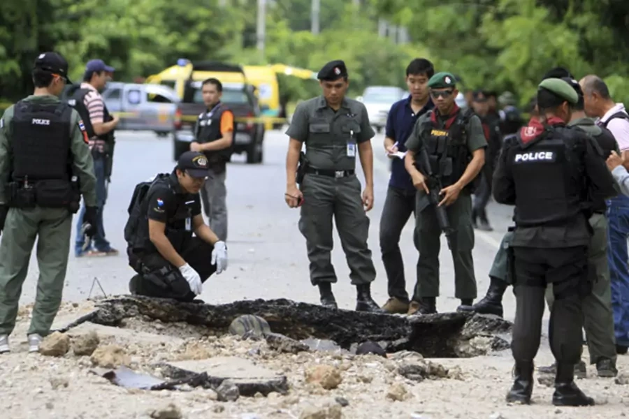 Thai security personnel investigate the site of a bomb attack by suspected Muslim militants a roadside in southern Thailand's Yala province October 6, 2012.