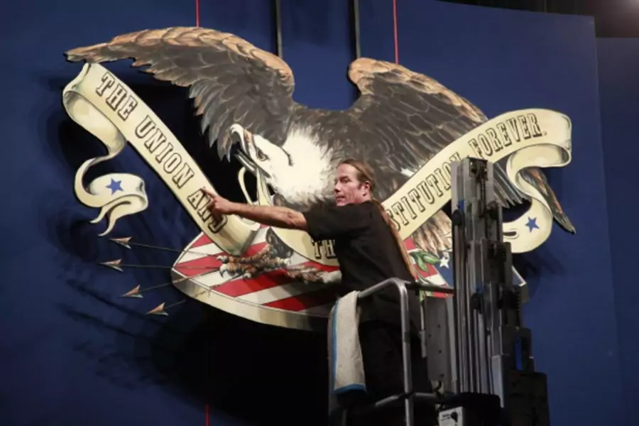 A worker helps to erect an ornamental eagle on the stage for the U.S. presidential debate in Denver, Colorado (Rick Wilking/Courtesy Reuters).