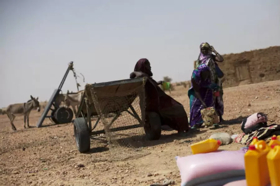 Women wait to load their cart with bags of rice and bottles of cooking oil at a food distribution center run by the Spanish No...a el Hambre (Action against Hunger) in Tarenguel, Gorgol region, in Mauritania on May 30, 2012 (Susana Vera/Courtesy Reuters).