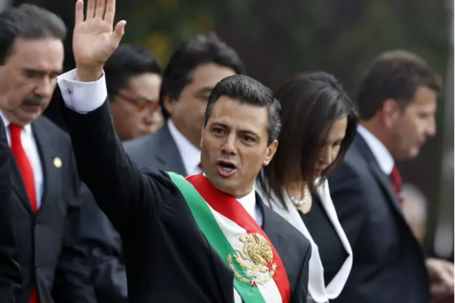 Mexico's new President Enrique Pena Nieto waves after taking oath in congress in Mexico City (Stringer/Courtesy of Reuters).