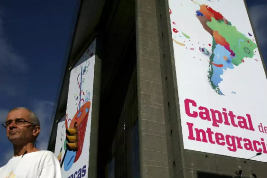 A man walks past a banner reading 'Capital of integration' in Caracas