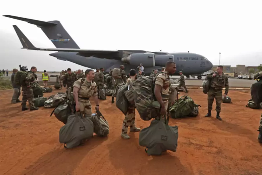 French soldiers carry their equipment after arriving in Bamako, Mali on a U.S. transport plane (Eric Gaillard/Courtesy Reuters).