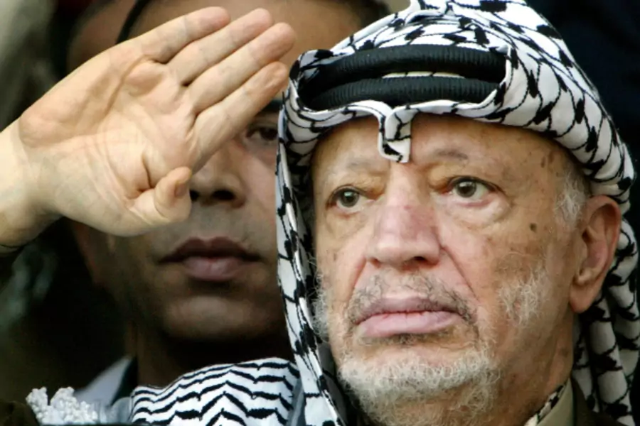Former Palestinian president Yasir Arafat salutes during a rally at his headquarters in the West Bank city of Ramallah September 14, 2003. (Courtesy REUTERS/Goran Tomasevic GOT/jm).