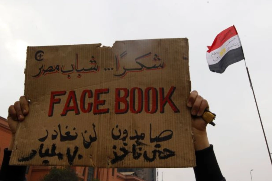 An opposition supporter lifts a placard at the front line near Tahrir Square in Cairo, Egypt, in July 2011 (Yannis Behrakis/Courtesy Reuters).