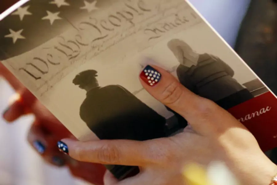 A woman reads a pamphlet prior to being naturalized as a U.S. citizen during a ceremony at the John F. Kennedy Library in Boston, Massachusetts July 14, 2010.