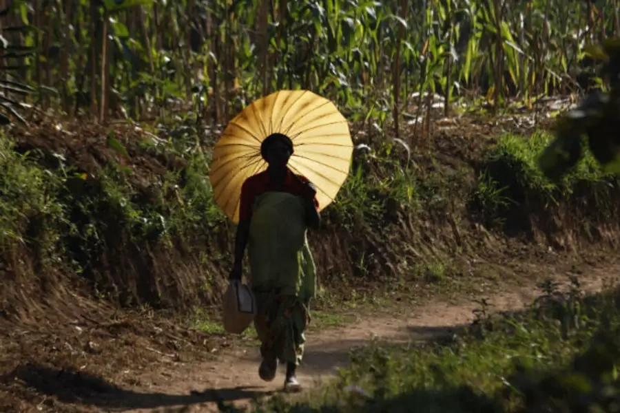 A Rwandan woman carries an umbrella for shade at Mulindi, about 60 km (40 miles) north of the capital Kigali on August 5, 2010 (Finbarr O'Reilly/Courtesy Reuters).