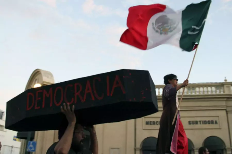 A protester holds a symbolic coffin who reads "democracy" during a demonstration in support of Andres Manuel Lopez Obrador, runner-up in Mexico's presidential race, after a court threw out his challenge to the poll result, in Hermosillo September 1, 2012.