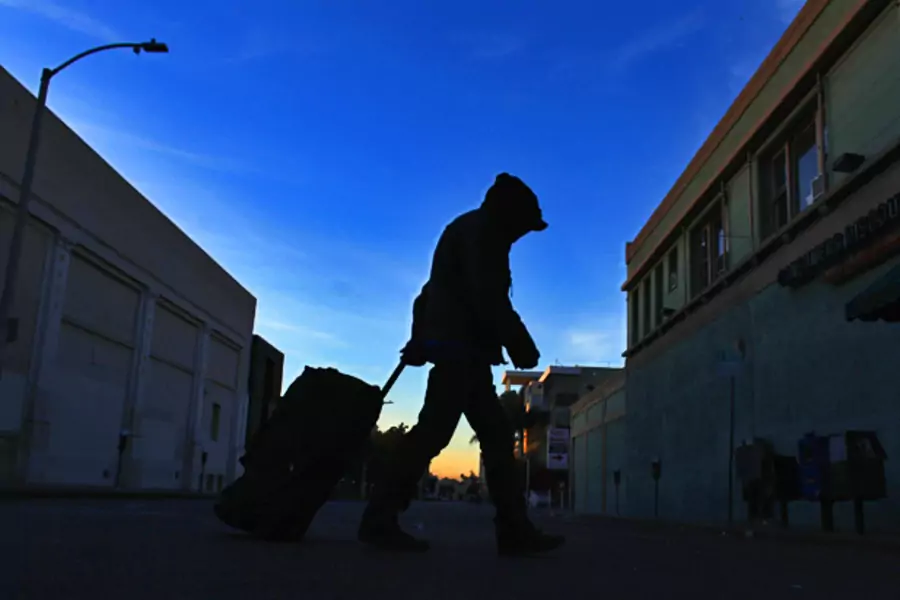 A homeless man makes his way down the street before sunrise (Mike Blake/Courtesy Reuters).