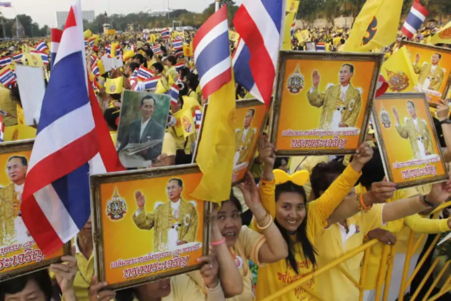 People hold pictures of Thailand's king Bhumibol Adulyadej as they wait for him to arrive at the Anantasamakom Throne Hall in Bangkok.