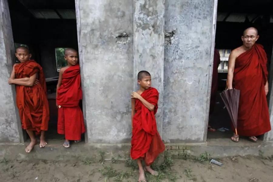 Buddhist novice monks look from a monastery during fighting between Buddhist Rakhine and Muslim Rohingya communities in Rakhine State.