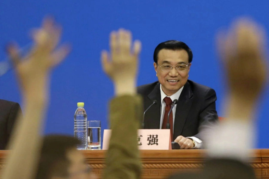 China's newly-elected premier Li Keqiang smiles as he takes questions during a news conference after the closing session of the National People's Congress in Beijing March 17, 2013.