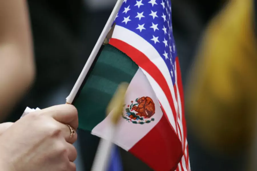 A woman holds a Mexican flag and a U.S. flag at a May Day rally for immigrants' and workers' rights in Portland, Oregon, May 1, 2007.
