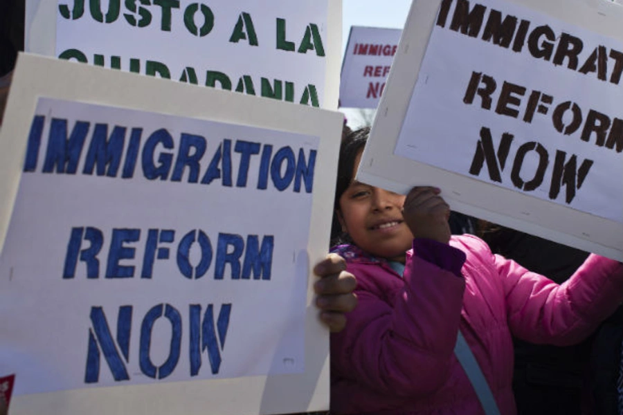 A girl holds up a banner while people take part in a rally to demand that Congress fix the broken immigration system at Liberty State Park in Jersey City, New Jersey, April 6, 2013 (Eduardo Munoz/Courtesy Reuters).