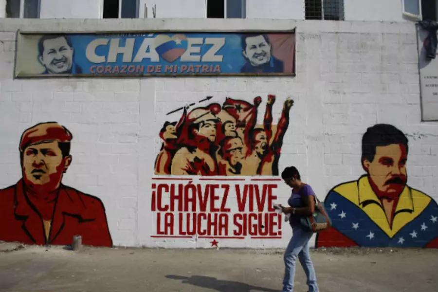 A woman walks past a mural depicting Venezuela's acting President and presidential candidate Nicolas Maduro (R) and Venezuela's late President Hugo Chavez in Caracas April 12, 2013 (Tomas Bravo/Courtesy Reuters).