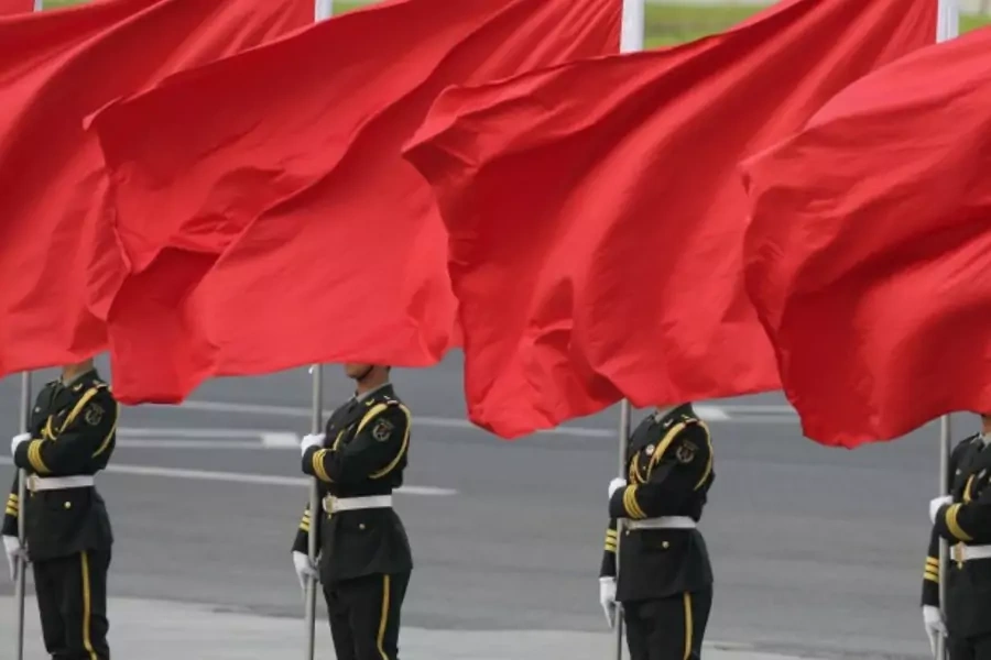 Members of the People's Liberation Army guard of honour stand with red flags during an official welcome ceremony outside the Great Hall of the People, in Beijing on April 15, 2013. (Courtesy Reuters/Jason Lee)