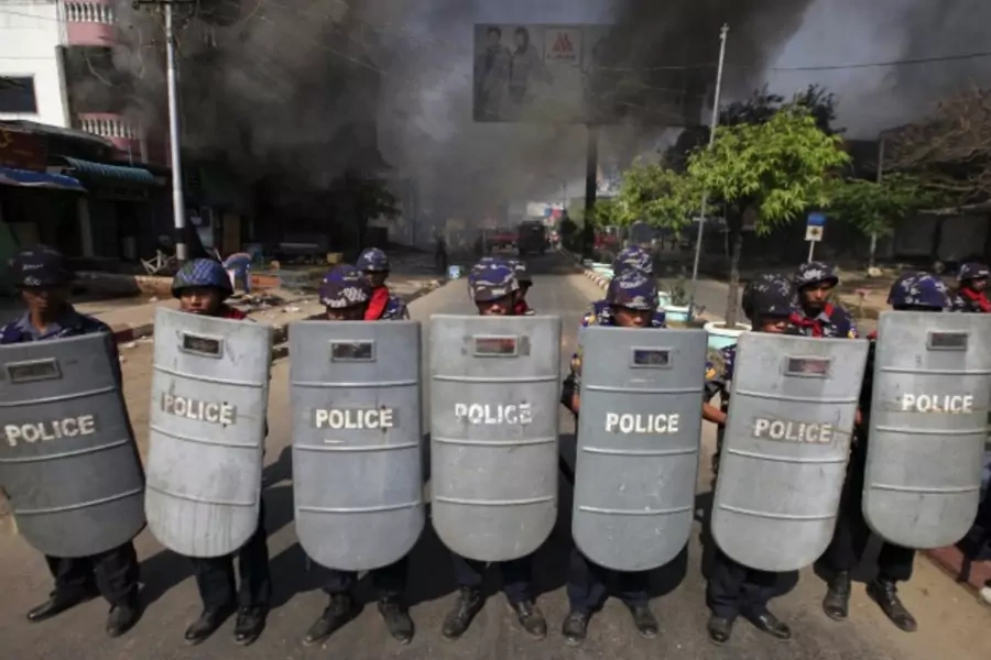 Riot policemen form up near a fire during riots in Meikhtila on March 22, 2013.