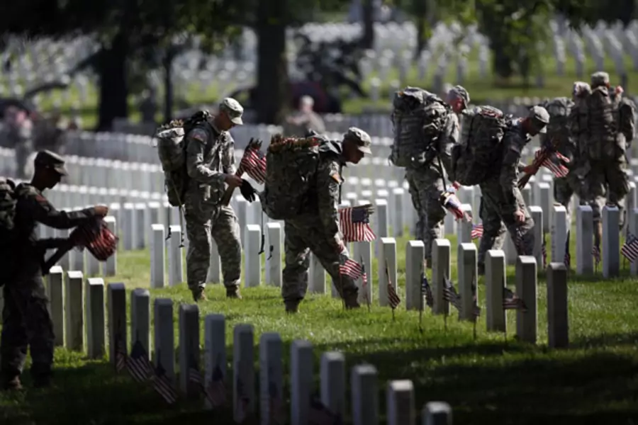 Members of the U.S. Army Old Guard place a flag at each of the more than 220,000 graves at Arlington National Cemetery (Jason Reed/Courtesy Reuters).
