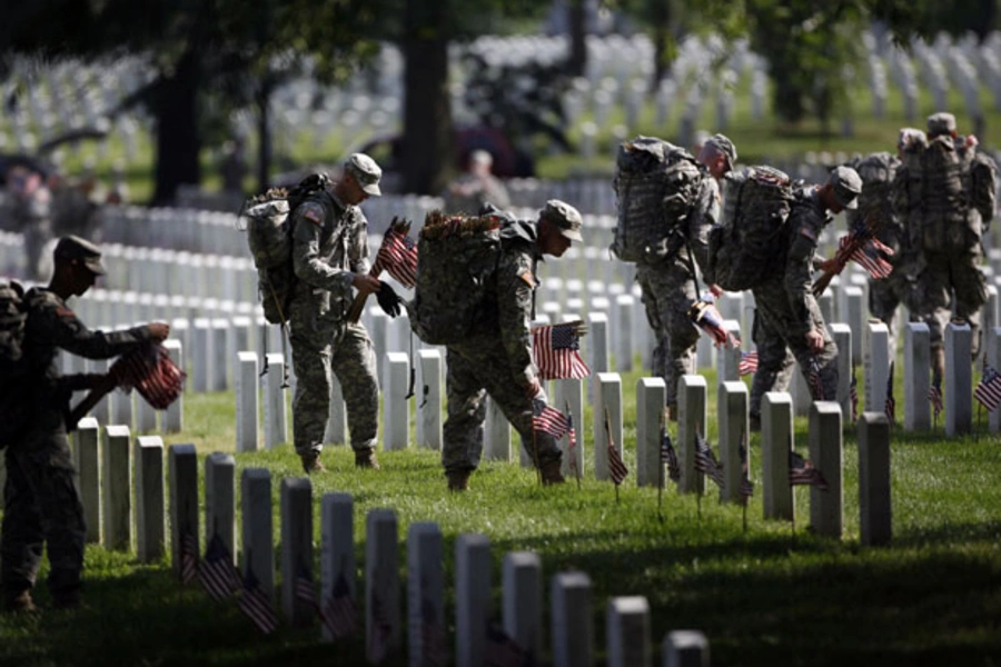 Members of the U.S. Army Old Guard place a flag at each of the more than 220,000 graves at Arlington National Cemetery (Jason Reed/Courtesy Reuters).