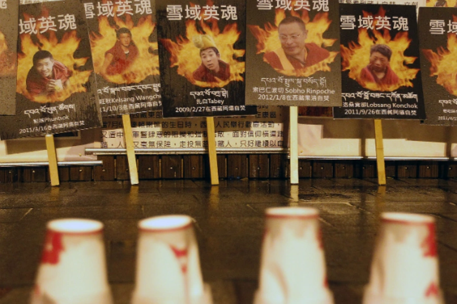 Portraits of Tibetans who killed themselves in self-immolation are seen behind candles in a candlelight vigil.