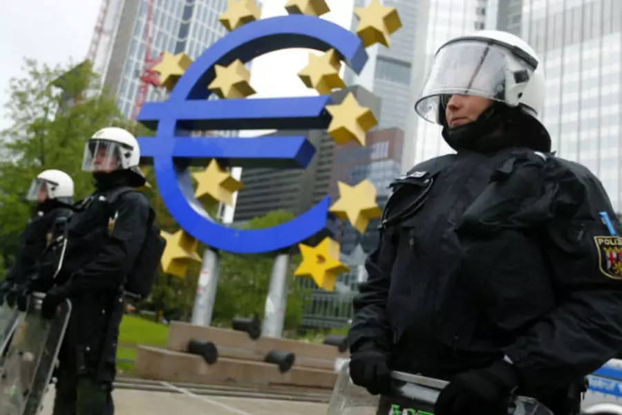 Global financial recessions have created pressure on democratic systems. Riot police stand near the euro sign in front of the European Central Bank (ECB) headquarters during an anti-capitalist "Blockupy" demonstration on May 31, 2013.