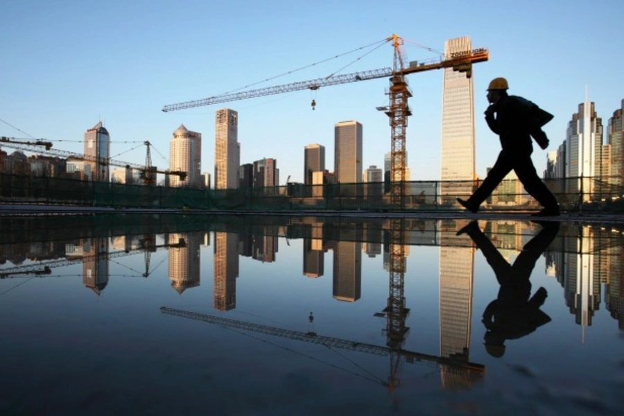 A worker walks past a pool of water inside a construction site in central Beijing on April 6, 2013.
