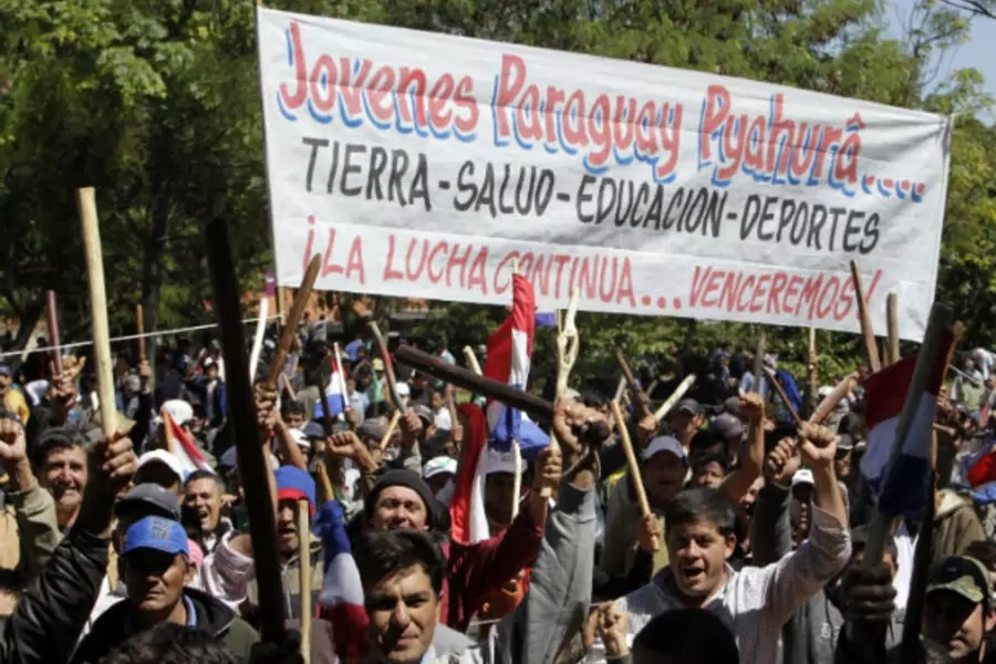 Paraguayan peasants hold up pieces of wood as they arrive in Auncion for the annual "March of the rural poor" on March 28, 2012 (Jorge Adorno/Courtesy Reuters).