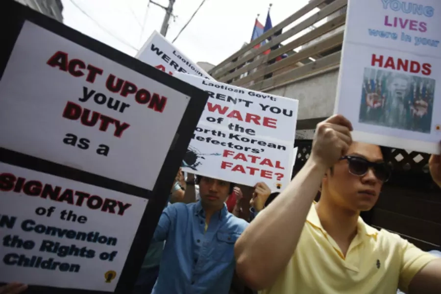 Protesters from a human rights group hold signs during a rally against Laos' recent repatriation of nine North Korean defectors, in front of the Laotian embassy in Seoul on May 31, 2013. (Kim Hong-Ji/Courtesy Reuters)