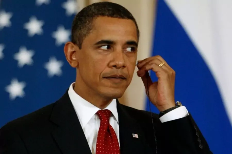 U.S. President Barack Obama adjusts his translators ear piece.